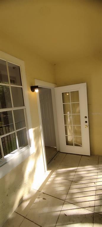 A covered patio features a white French door, a window, and light-colored tile flooring — 2544 ROBERT TRENT DRIVE UNIT 825, ORLANDO, FL