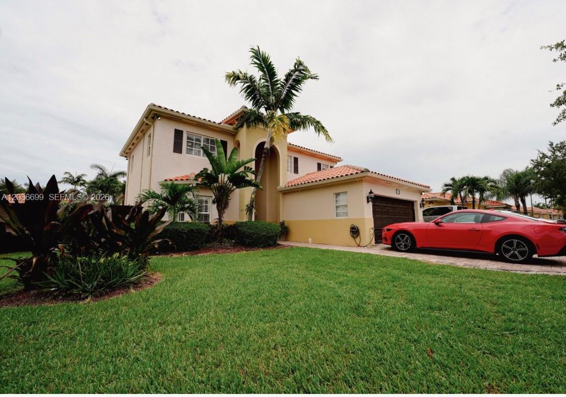 A two-story stucco house with a tile roof, palm tree, and red car parked outside — 1935 NE 35th Ave, Homestead FL 33033, HOMESTEAD, FL