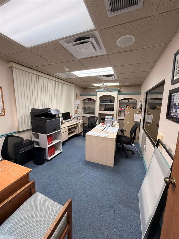 An office space features a desk, printer, shelving, and blue carpeting under a drop ceiling — 13610 LEARNING COURT, FORT MYERS, FL