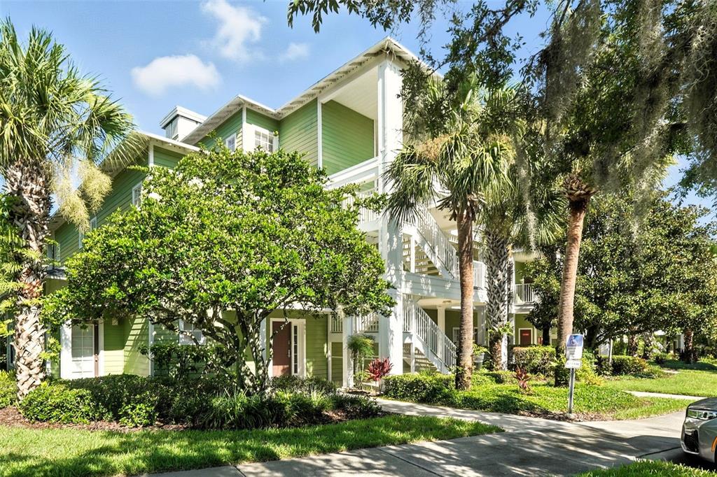 A three-story green apartment building with white trim and exterior staircases surrounded by trees — 809 GRAN BAHAMA BOULEVARD UNIT 30809, DAVENPORT, FL