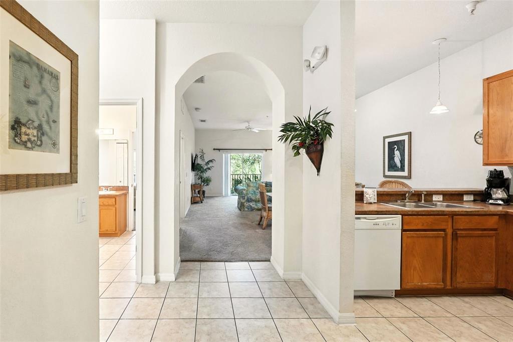 A tiled entryway leads to a carpeted living area through an arched doorway near a kitchen — 809 GRAN BAHAMA BOULEVARD UNIT 30809, DAVENPORT, FL