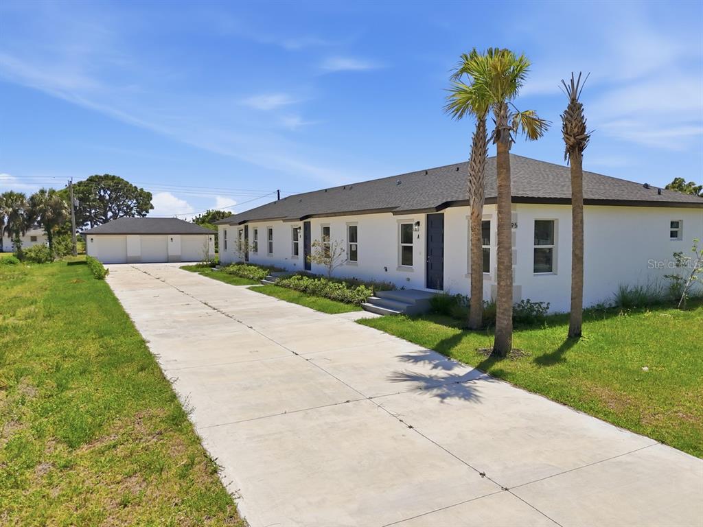 A modern kitchen features white cabinetry, stainless steel appliances, and light wood-look tile flooring — 195 ROTONDA BOULEVARD W UNIT 3, ROTONDA WEST, FL
