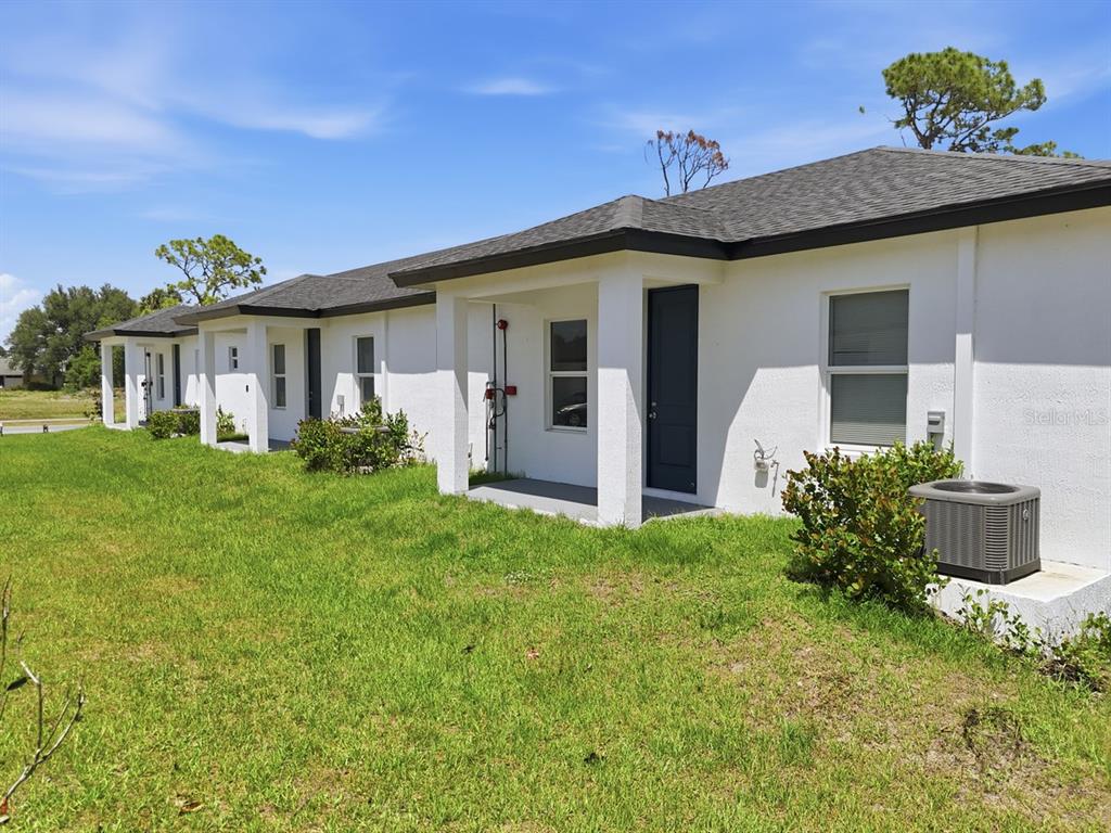 A row of white single-story residential units with dark roofs and small front porches — 195 ROTONDA BOULEVARD W UNIT 3, ROTONDA WEST, FL