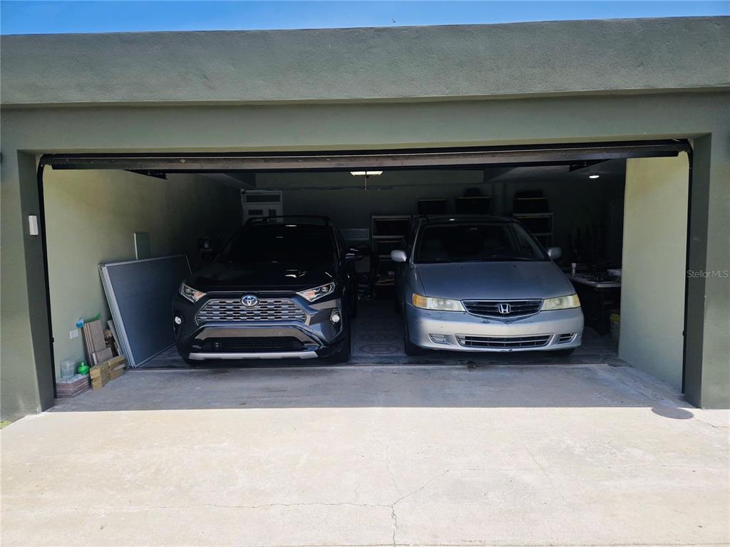 A two-car garage contains a black SUV and a silver minivan parked side by side — 2 ROOSEVELT GARDEN, CEIBA, PR