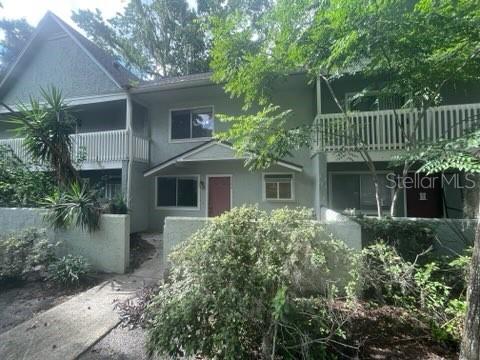 A two-story townhouse exterior with a light green facade, balconies, and a front walkway — 4411 SW 34TH STREET UNIT 1304, GAINESVILLE, FL