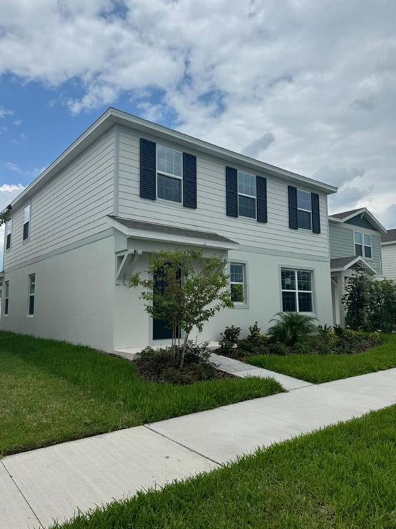A two-story house with light-colored siding, dark shutters, and a small front porch — 1782 GROVELINE ROAD, ST CLOUD, FL