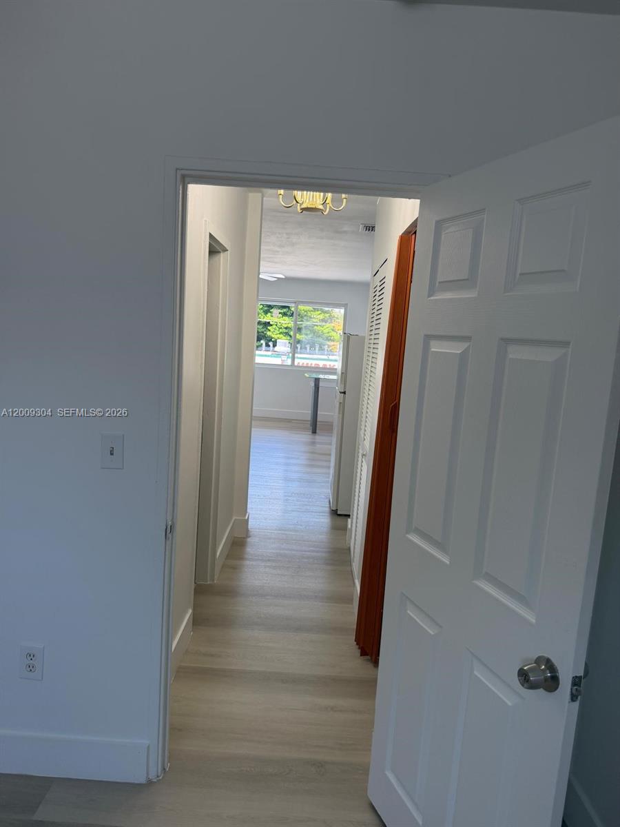 A view through an open doorway shows a hallway leading to a bright living area — 4840 NW 27th Ave # 2, Miami FL 33142, MIAMI, FL