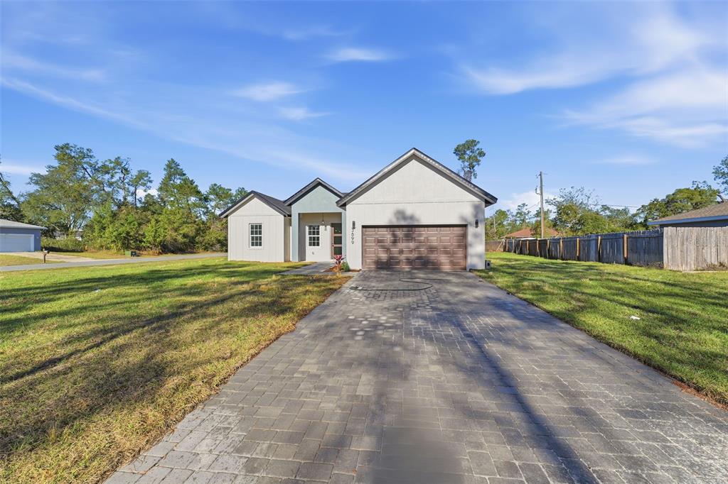 A single-story house with a paved driveway, a two-car garage, and a light-colored exterior — 3699 SW 169TH PLACE, OCALA, FL