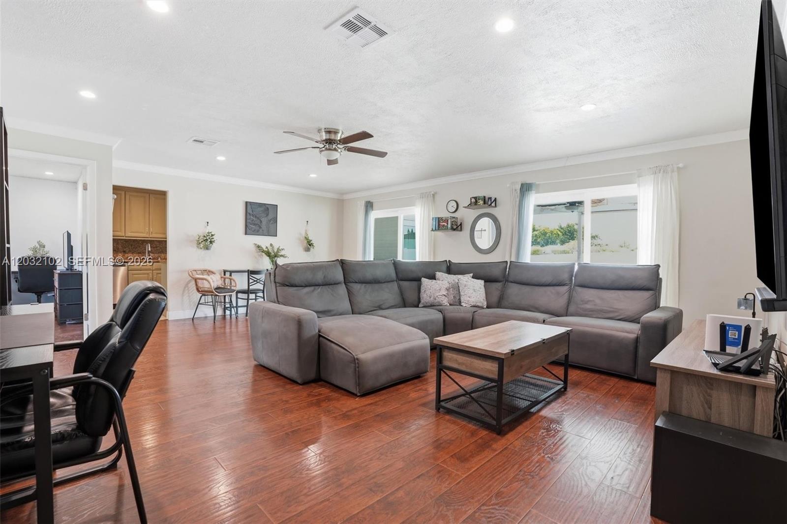 A living room features a large gray sectional sofa, wood flooring, and a ceiling fan — 13391 SW 78th St, Miami FL 33183, MIAMI, FL