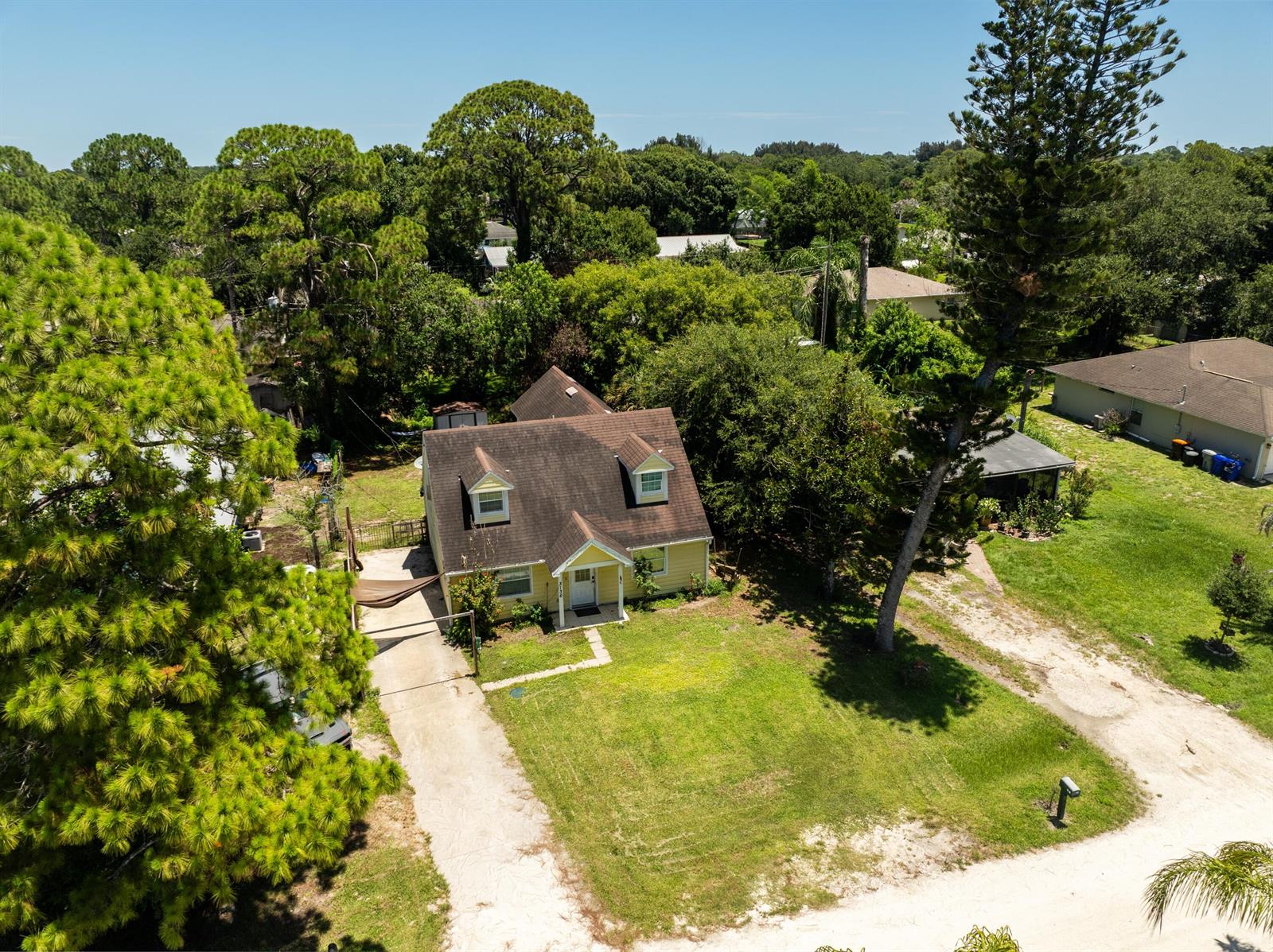 An aerial view shows a yellow two-story house with a brown roof and a driveway — 3136 2nd Street, Vero Beach FL 32968, VERO BEACH, FL