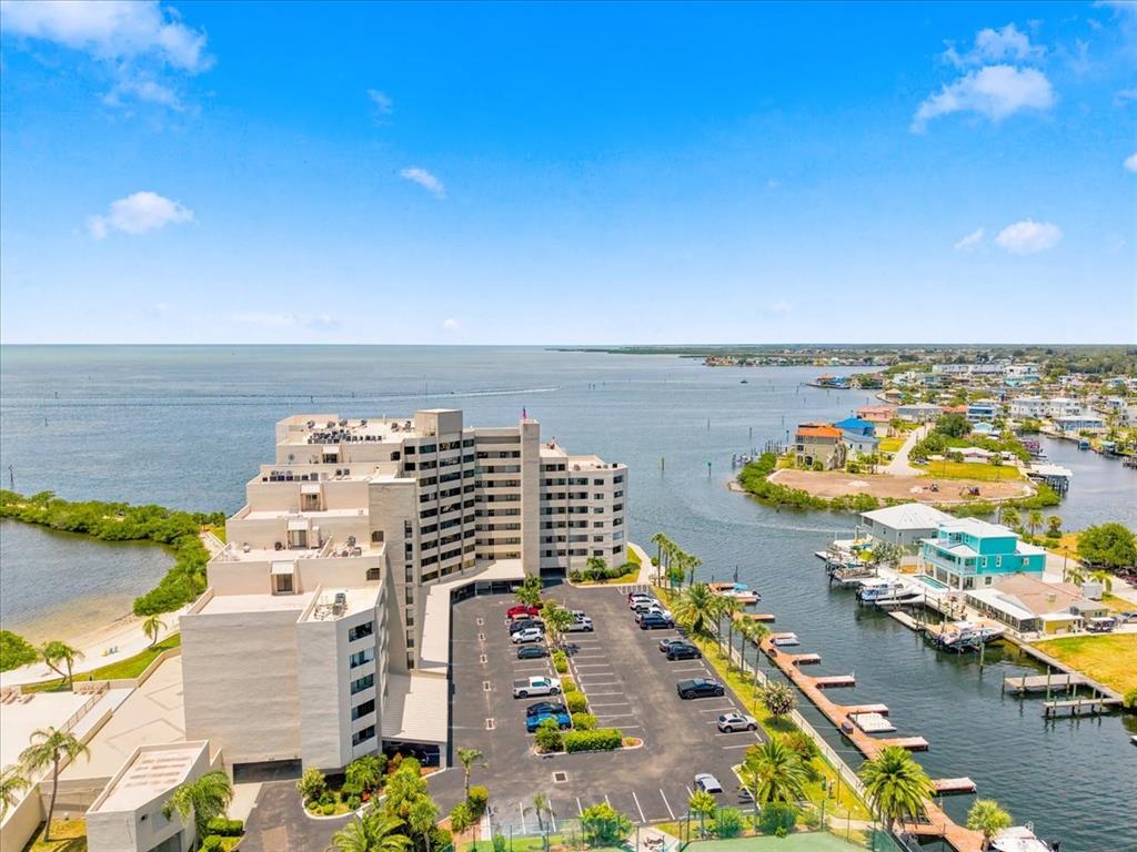 An aerial view of a multi-story apartment building with a parking lot and boat docks — 6035 SEA RANCH DRIVE UNIT 100, HUDSON, FL
