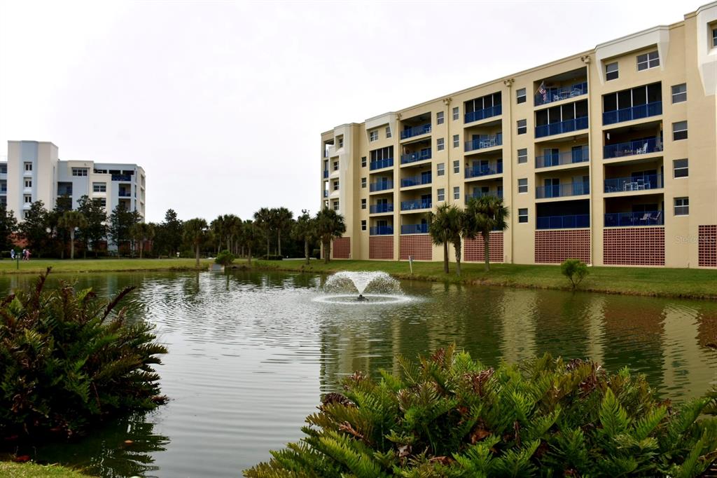 A pond with a fountain sits in front of two large multi-story apartment buildings — 5300 S ATLANTIC AVENUE UNIT 8-402, NEW SMYRNA BEACH, FL