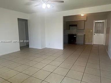 An open-concept living area features light-colored tile flooring and a view into the kitchen — 2407 Mckinley St # 2, Hollywood FL 33020, HOLLYWOOD, FL