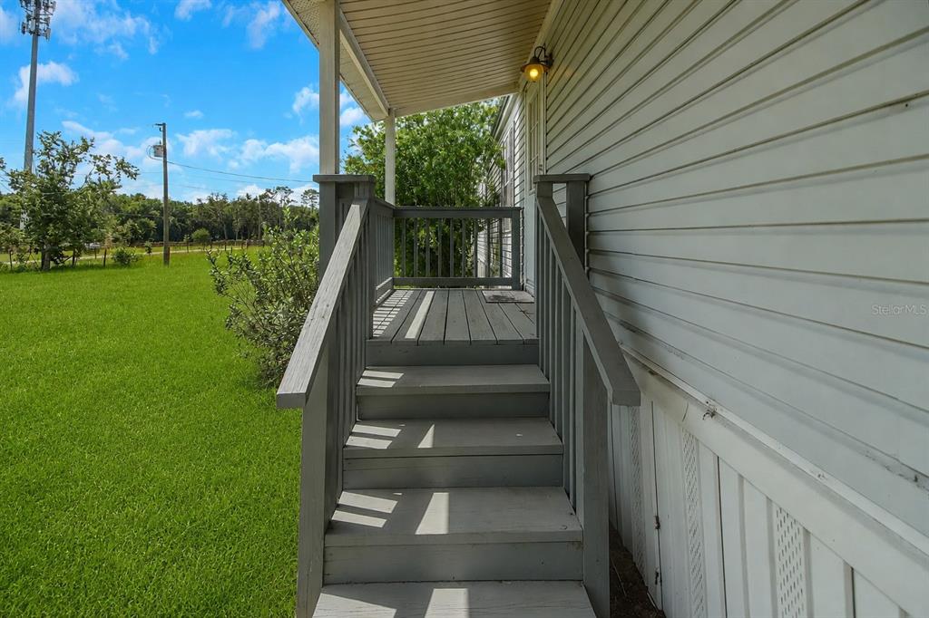 A set of wooden stairs leads up to a covered porch on a mobile home — 7438 CR 663, BUSHNELL, FL