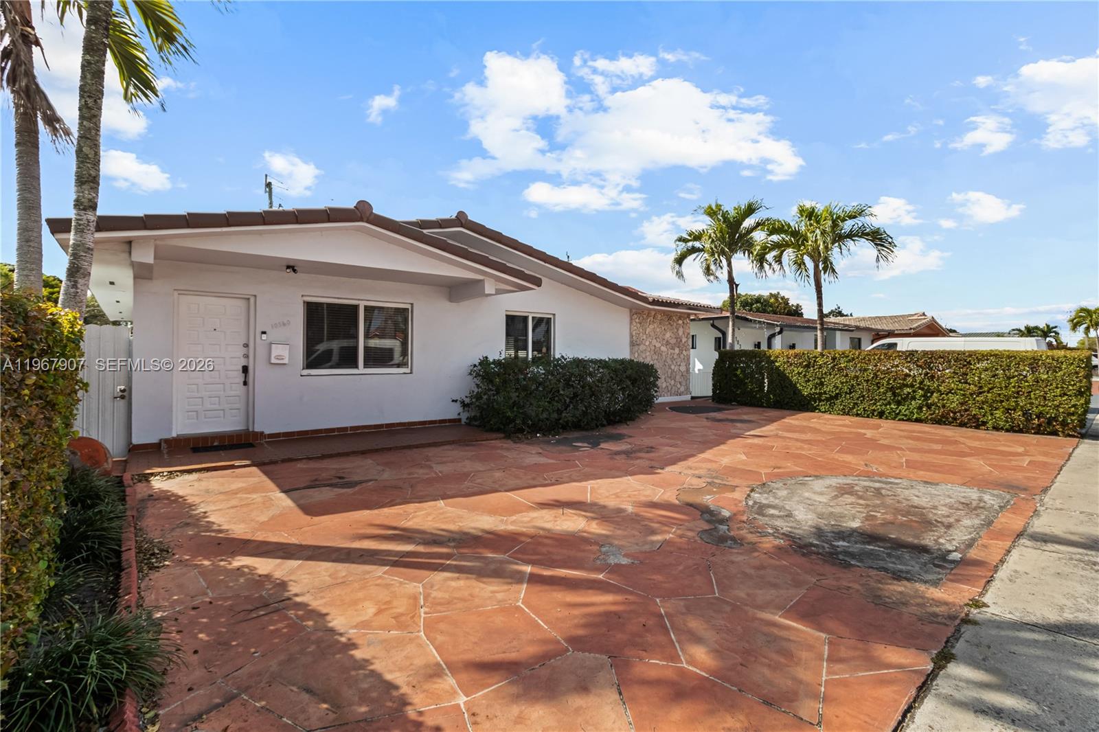A single-story house with a white exterior, stone accents, and a red flagstone driveway — 10360 SW 24th St, Miami FL 33165, MIAMI, FL