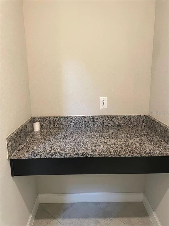 A small alcove features a granite countertop, a black apron, and a wall-mounted electrical outlet — 9671 IVORY DRIVE, SUN CITY CENTER, FL