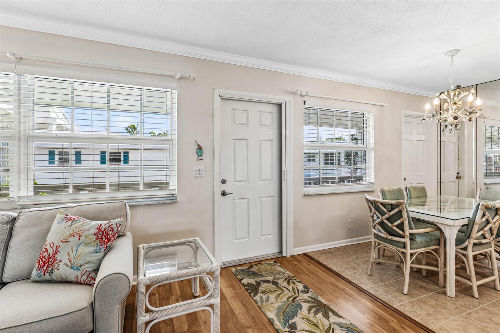 A living and dining area features wood and tile flooring, a glass table, and windows — 5505 N Ocean Boulevard # 204, Ocean Ridge FL 33435, OCEAN RIDGE, FL