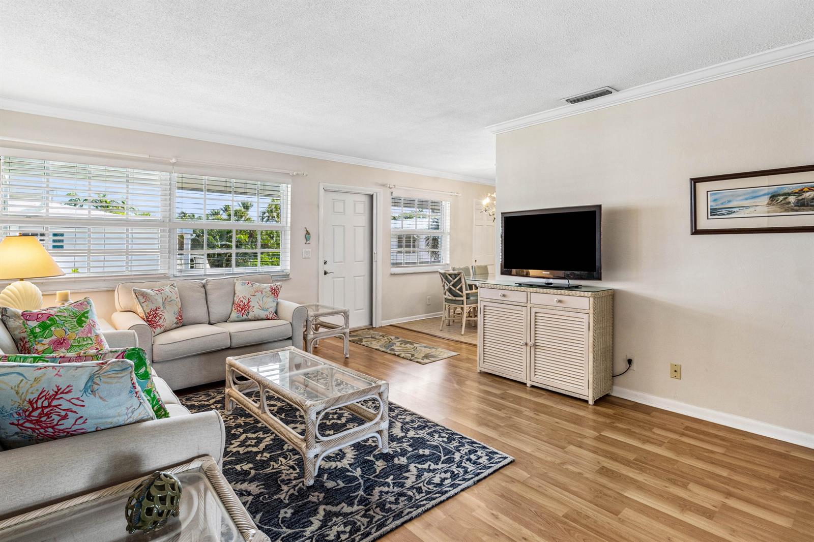 A living room features light wood floors, a patterned area rug, and a television console — 5505 N Ocean Boulevard # 204, Ocean Ridge FL 33435, OCEAN RIDGE, FL