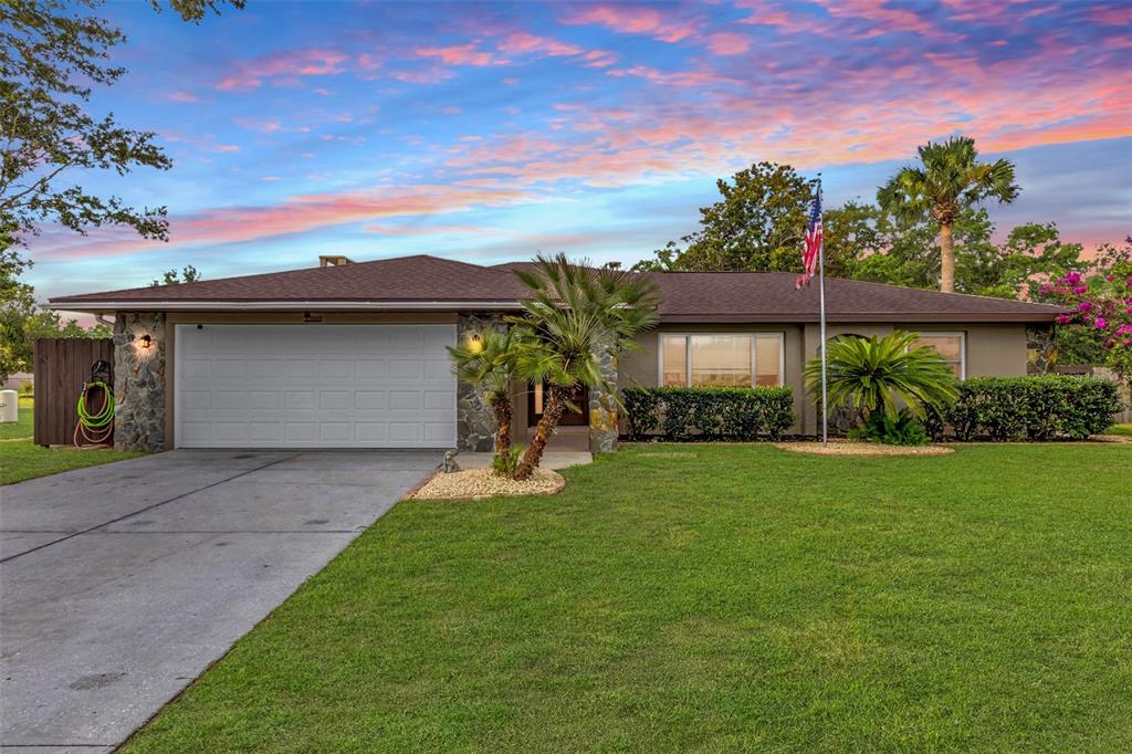 A single-story house with a stone facade, a two-car garage, and a front lawn — 5202 SYDNEY ROAD, FRUITLAND PARK, FL