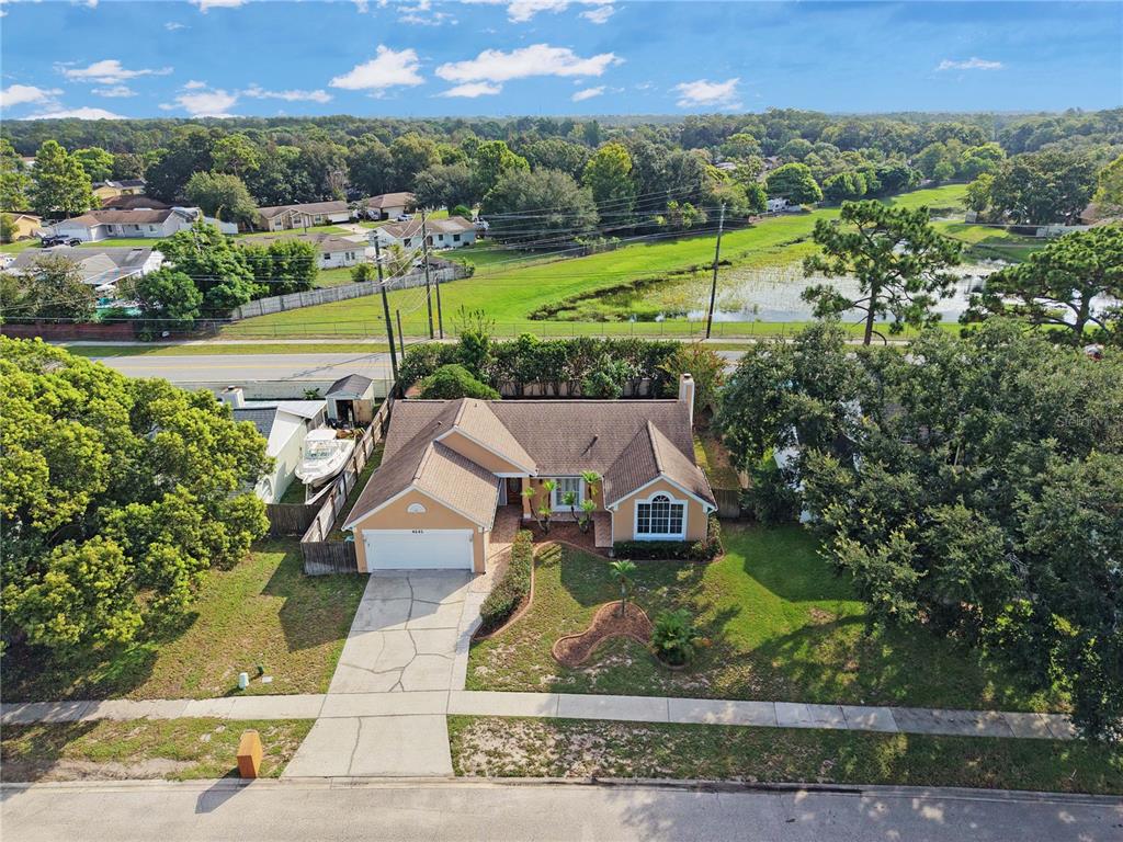An aerial view of a single-story house with a tan exterior and a two-car garage — 4645 SADDLE CREEK PLACE, ORLANDO, FL