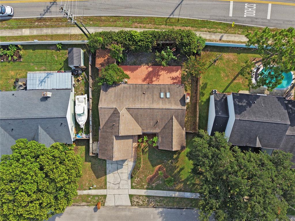 An aerial view shows a residential house with a driveway, backyard patio, and swimming pool — 4645 SADDLE CREEK PLACE, ORLANDO, FL