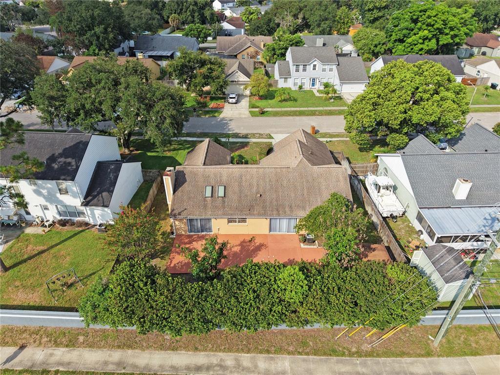 An aerial view shows a house with a brown roof, a patio, and a backyard hedge — 4645 SADDLE CREEK PLACE, ORLANDO, FL