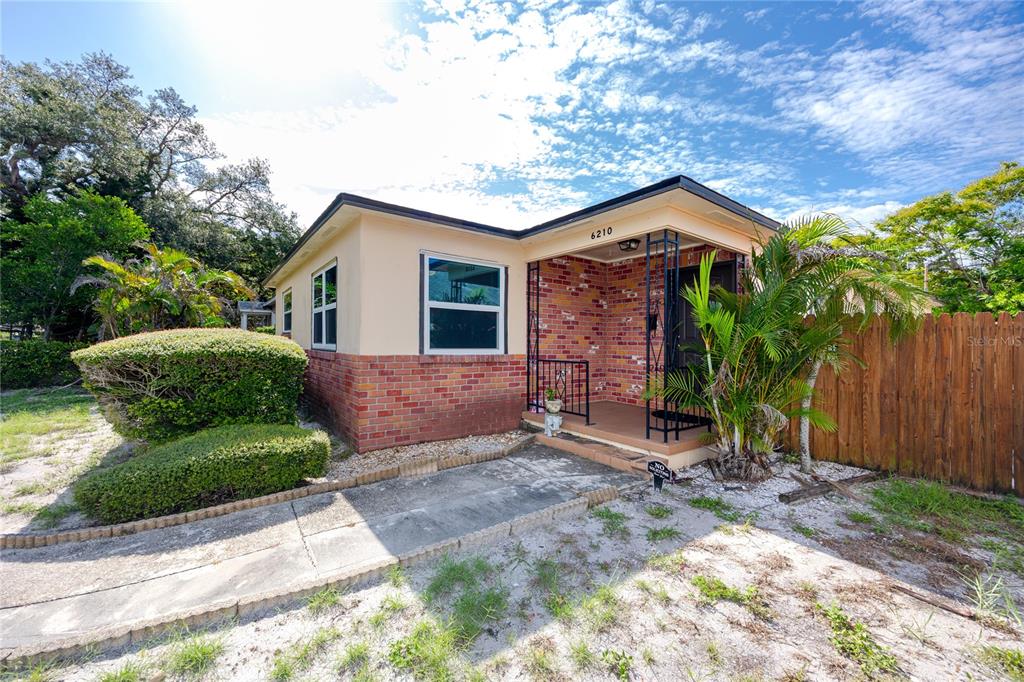 A single-story house with a brick facade, a covered porch, and a concrete walkway — 6210 4TH AVENUE S, ST PETERSBURG, FL