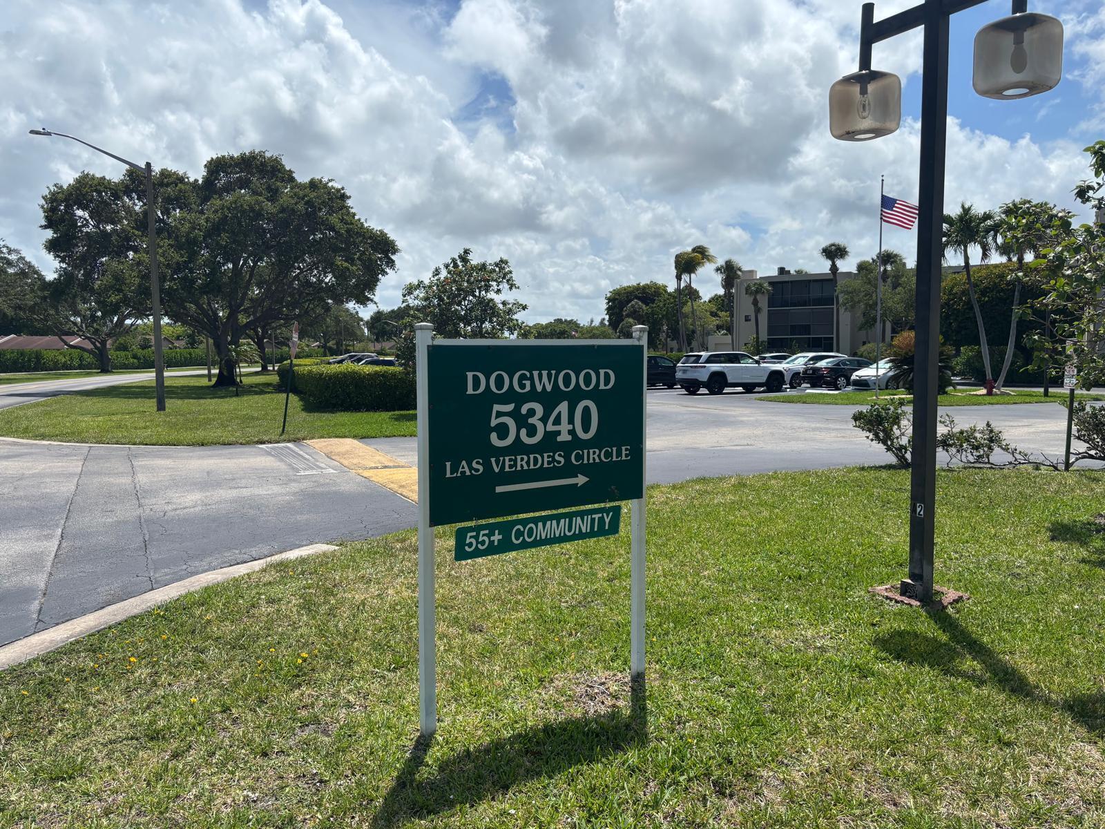 A green sign indicates the entrance to a 55+ community with a parking lot behind — 5340 Las Verdes Circle # 222, Delray Beach FL 33484, DELRAY BEACH, FL