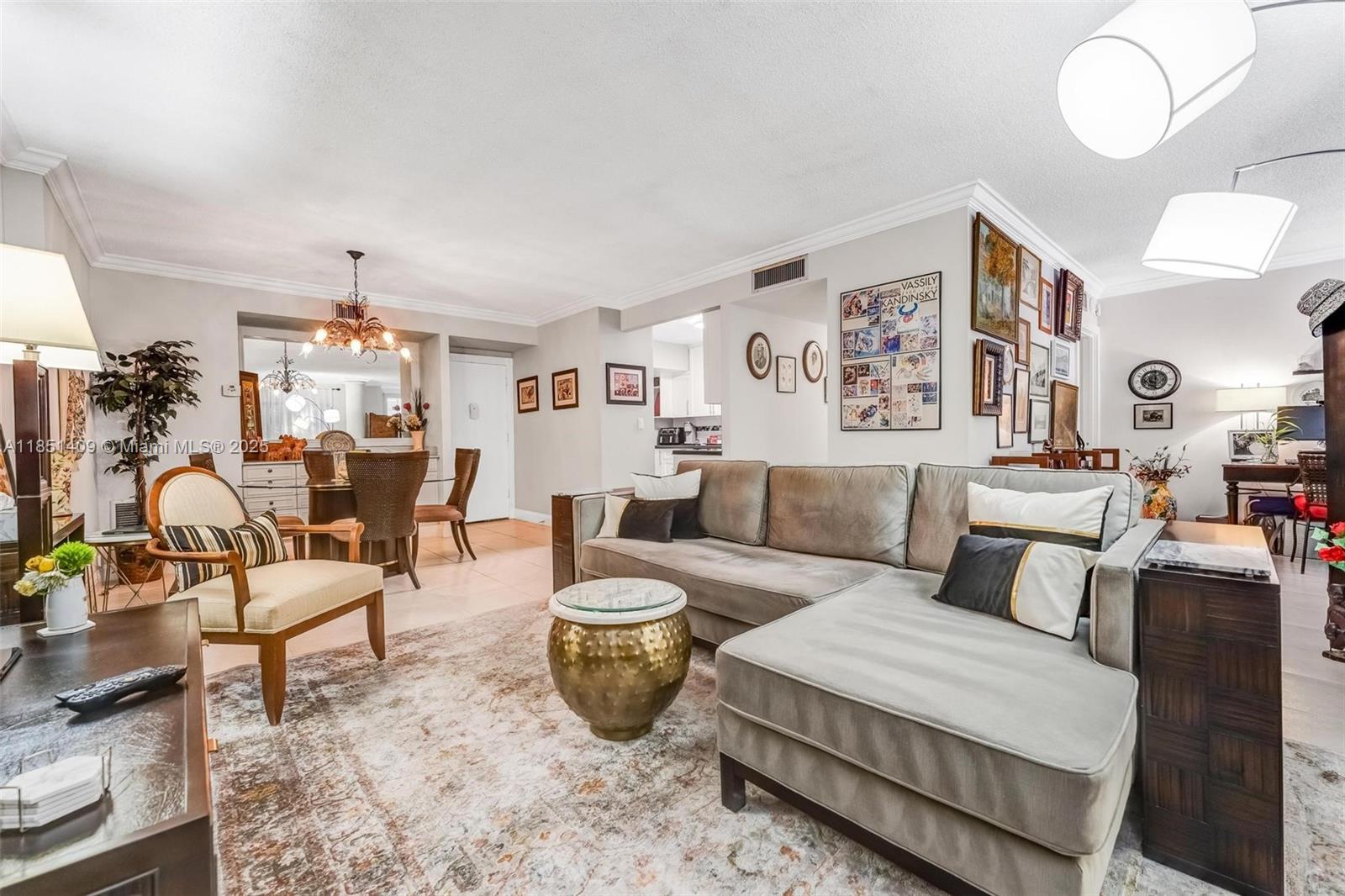 A living room features a grey sectional sofa, a gold drum table, and a dining area — 4330 Hillcrest Dr # 516, Hollywood FL 33021, HOLLYWOOD, FL