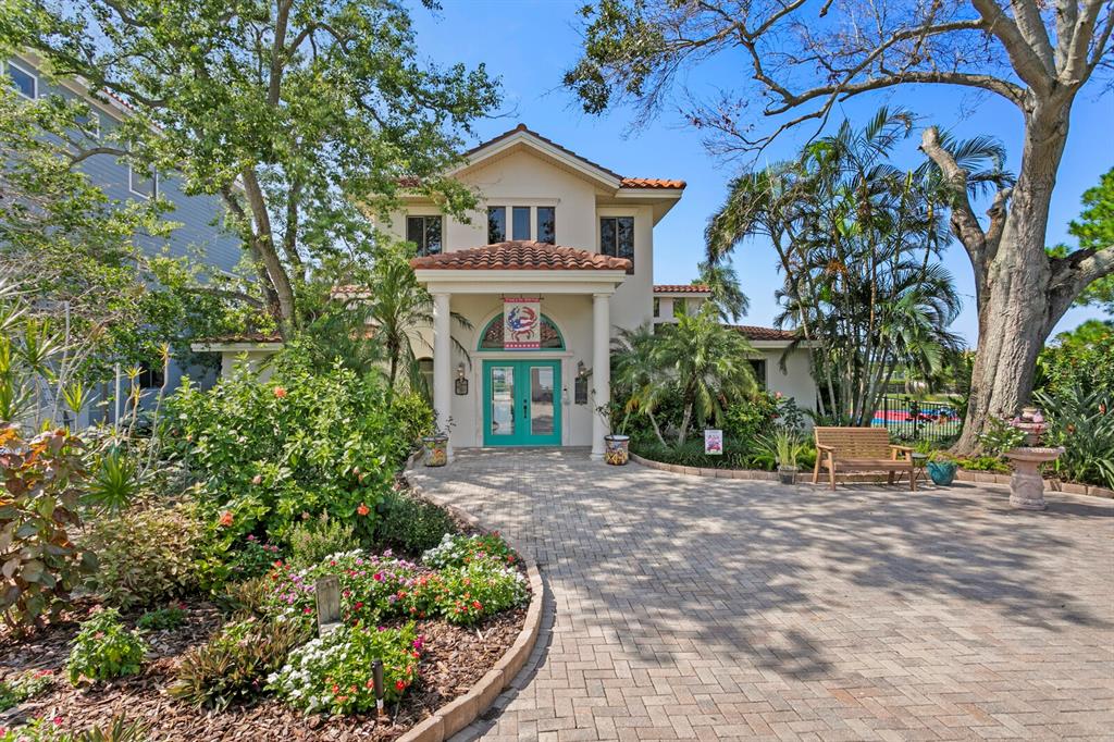 A paved driveway leads to the entrance of a two-story building with a tiled roof — 1632 SEA BREEZE DRIVE, TARPON SPRINGS, FL