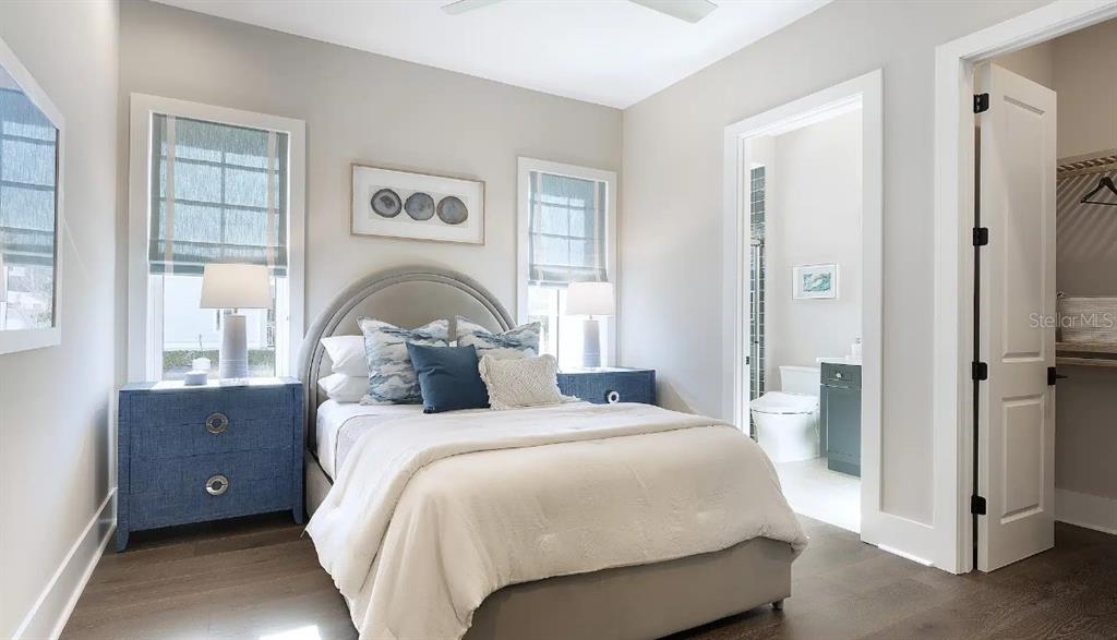 A bedroom features a bed with blue pillows, two blue nightstands, and an attached bathroom — 4299 ROYAL SKY COURT, BROOKSVILLE, FL