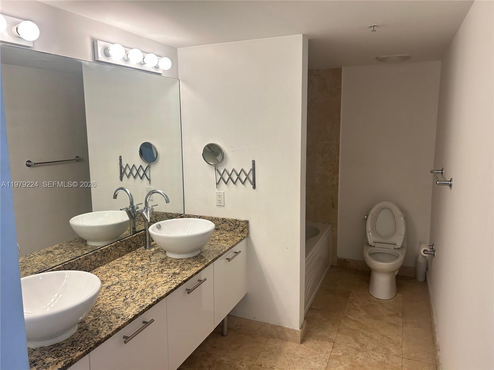 A bathroom features a double vanity with vessel sinks, granite countertops, and a separate toilet — 41 SE 5th St # 907, Miami FL 33131, MIAMI, FL