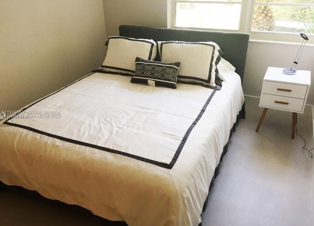A bedroom features a bed with white bedding and a small white nightstand — 100 Lincoln Rd # 426, Miami Beach FL 33139, MIAMI BEACH, FL