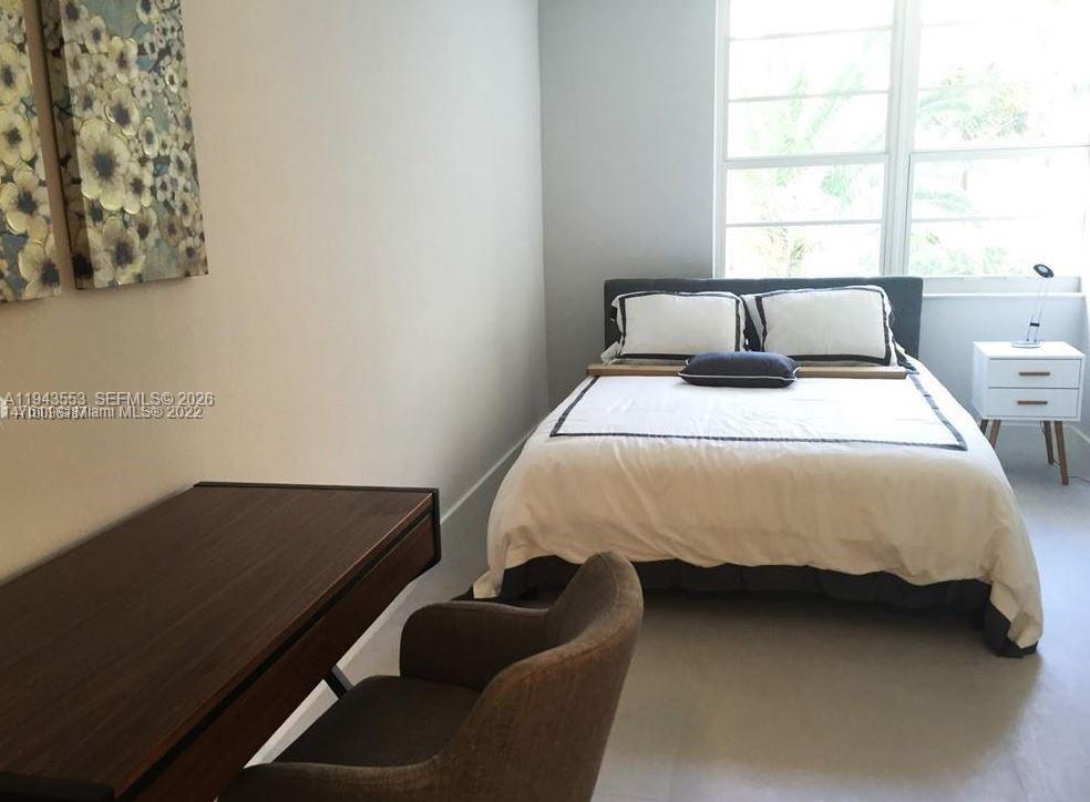 A bedroom features a bed with white bedding, a desk, and a chair — 100 Lincoln Rd # 426, Miami Beach FL 33139, MIAMI BEACH, FL