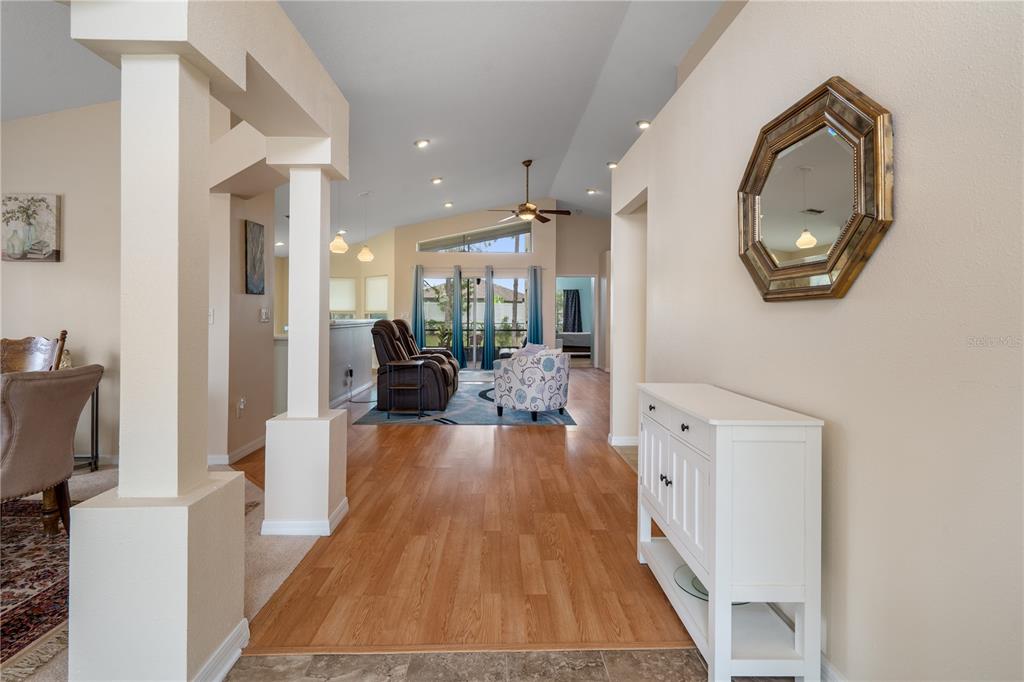 A view from a tiled entryway looking into a living room with wood-look flooring — 306 BARRINGTON COURT, SPRING HILL, FL