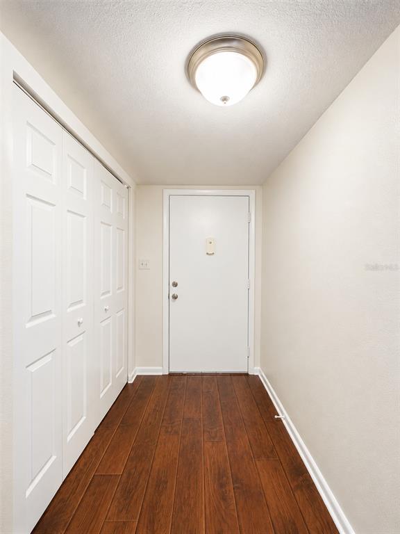 An entryway features a white door, a white bi-fold closet, and dark wood-look flooring — 568 BAHIA CIRCLE UNIT B, OCALA, FL