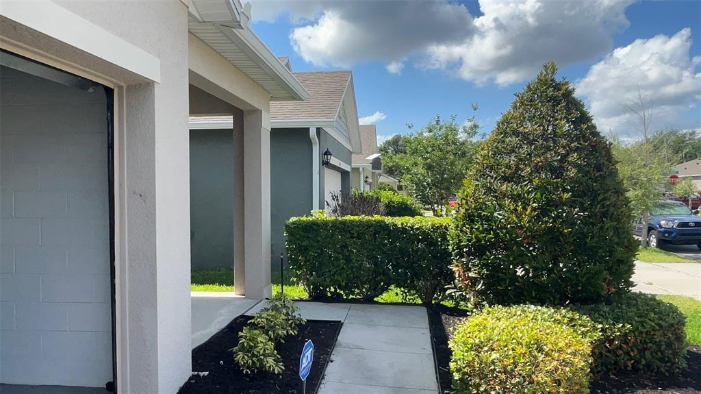 A view of a house exterior with a walkway, landscaping, and a parked blue truck — 864 GUNNISON DRIVE, ORANGE CITY, FL