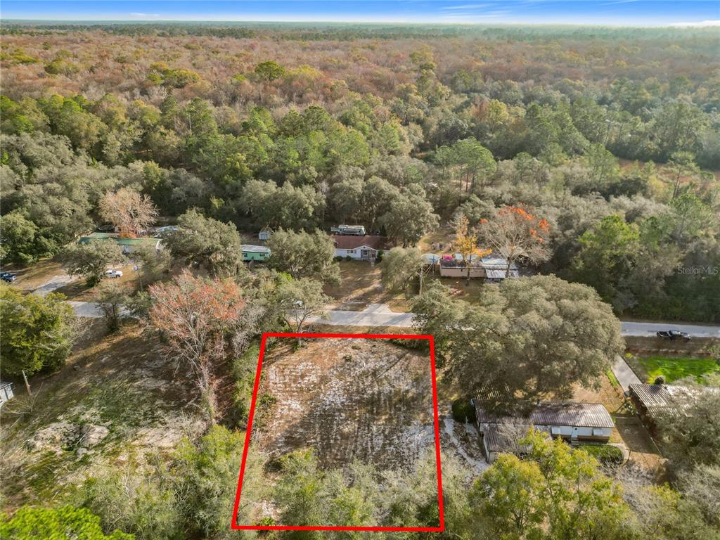 An aerial view shows a rectangular, cleared lot outlined in red near a paved road — 202 NE 72ND TERRACE, OCALA, FL