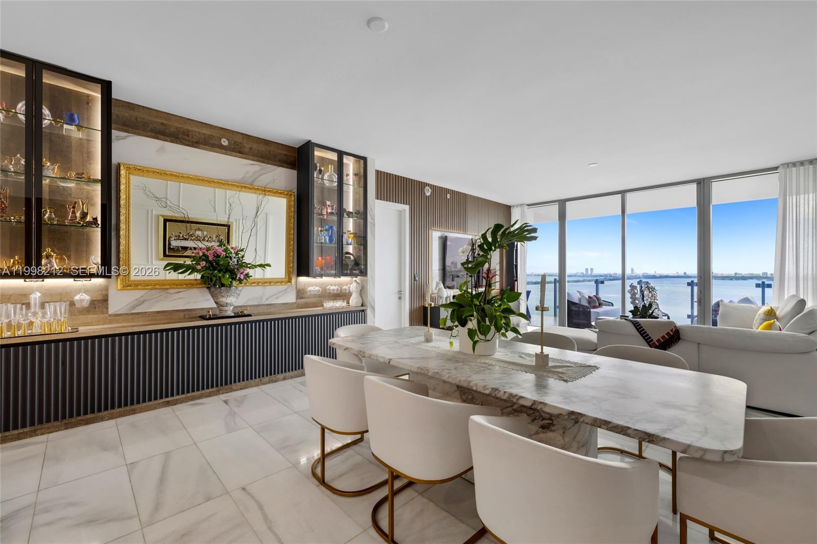 A dining room features a marble table, white chairs, and a built-in bar with shelving — 700 NE 26th Ter # 2202, Miami FL 33137, MIAMI, FL
