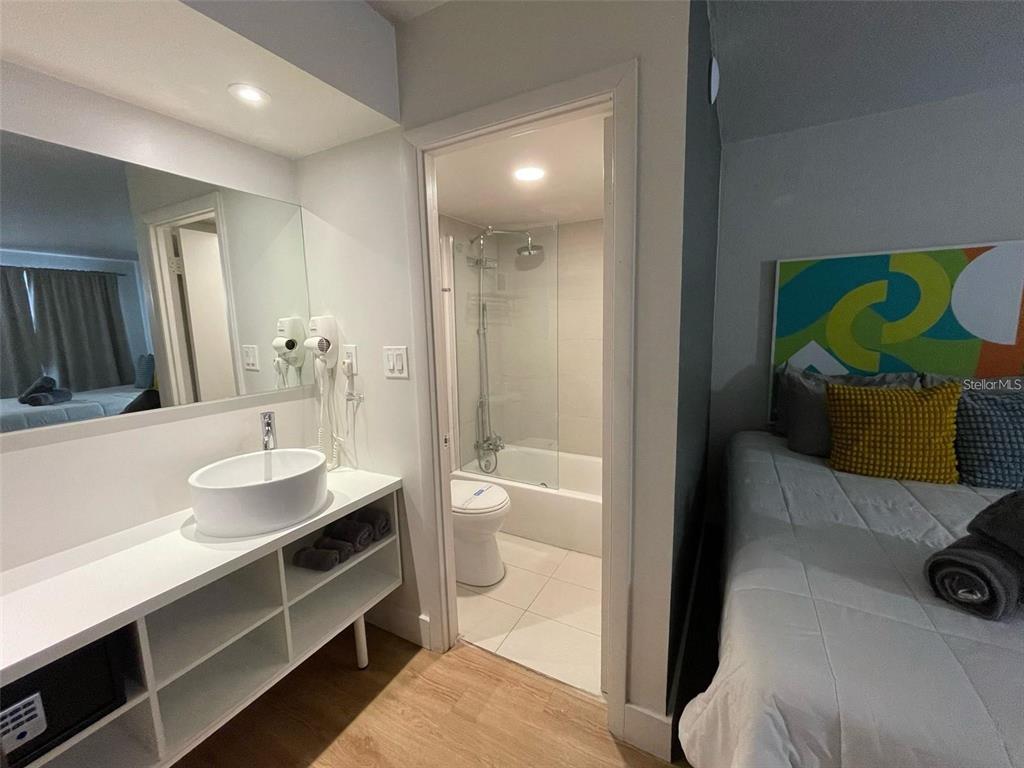 A hotel room features a vanity with a vessel sink, an attached bathroom, and a bed — 5367 W IRLO BRONSON MEM HWY UNIT 1-203, KISSIMMEE, FL