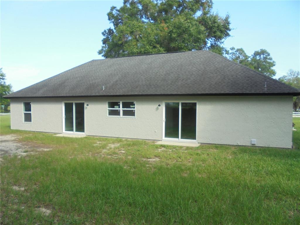 A bright, open-concept living and dining area features light gray wood-look flooring and white walls — 340 EMERALD ROAD, OCALA, FL