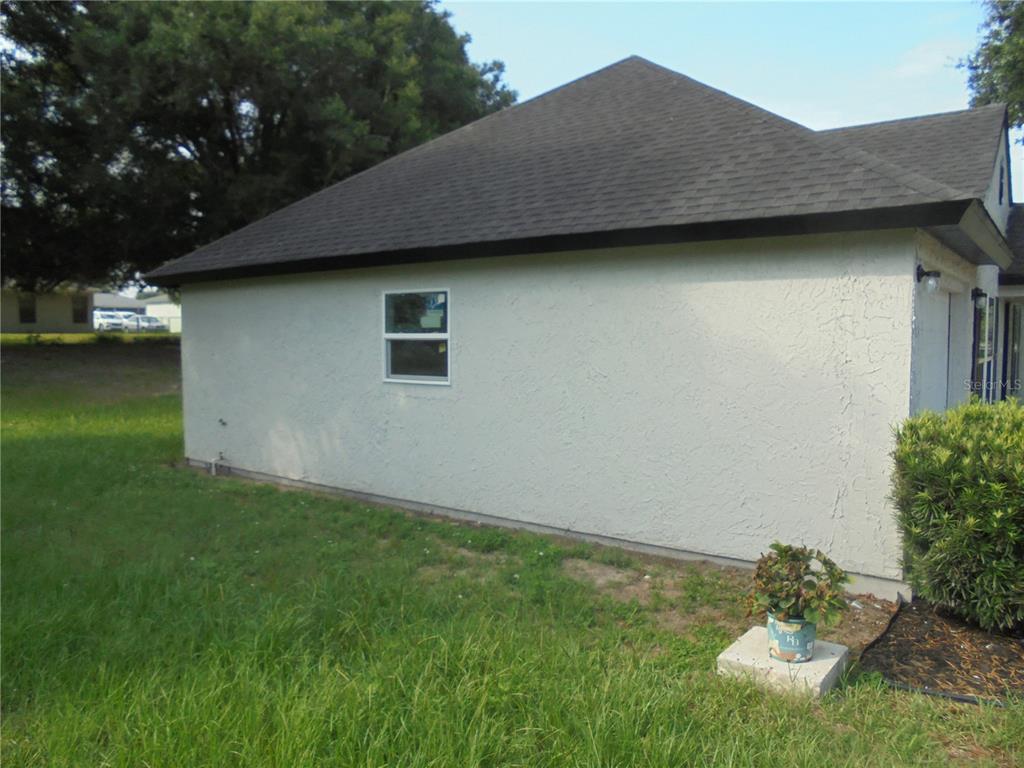 An empty room features white walls, gray wood-look flooring, a ceiling fan, and a window — 340 EMERALD ROAD, OCALA, FL