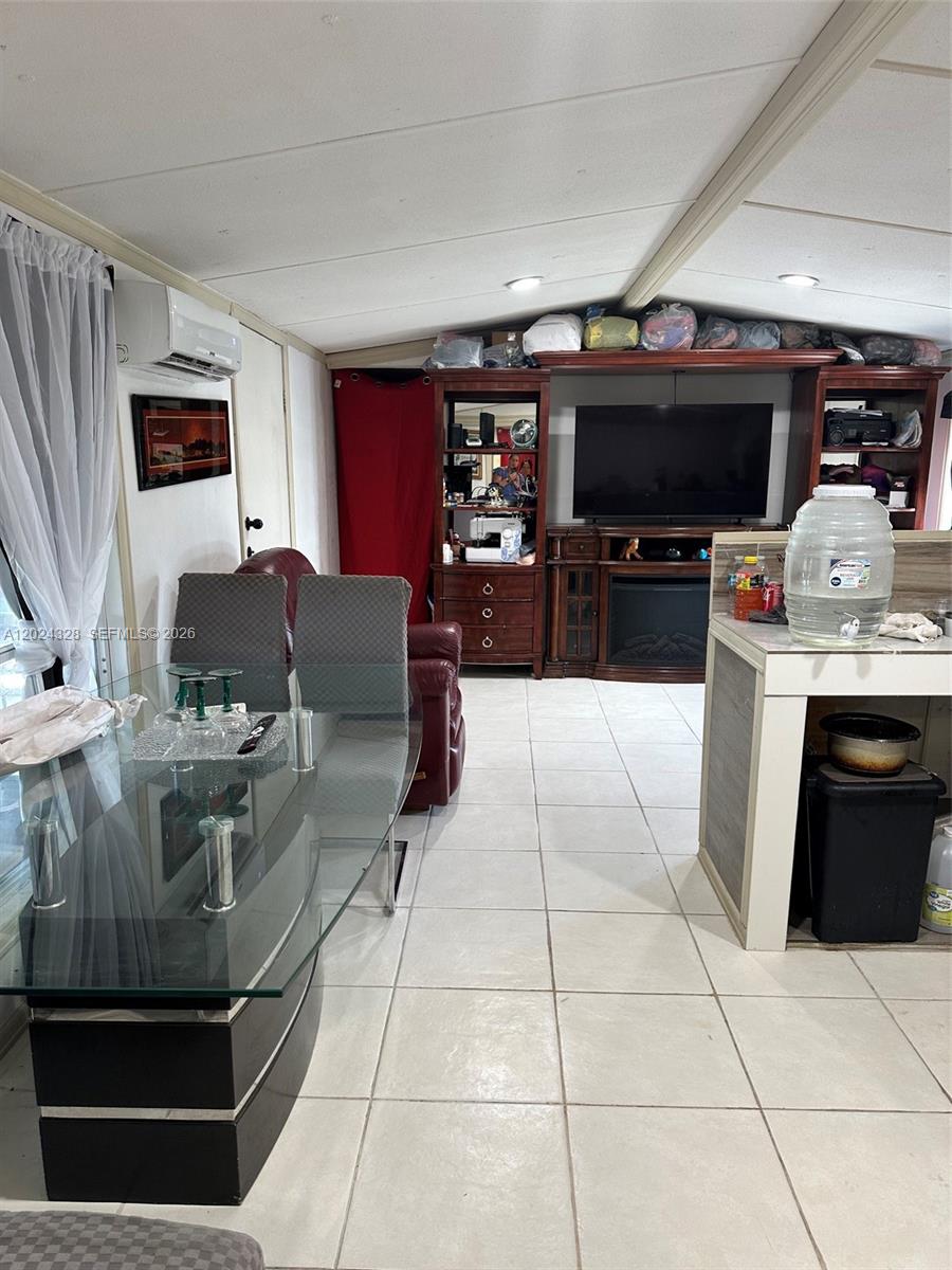A dining area with a glass table leads into a living space with a television — 625 N QUEBRADA, Clewiston FL 33440, CLEWISTON, FL