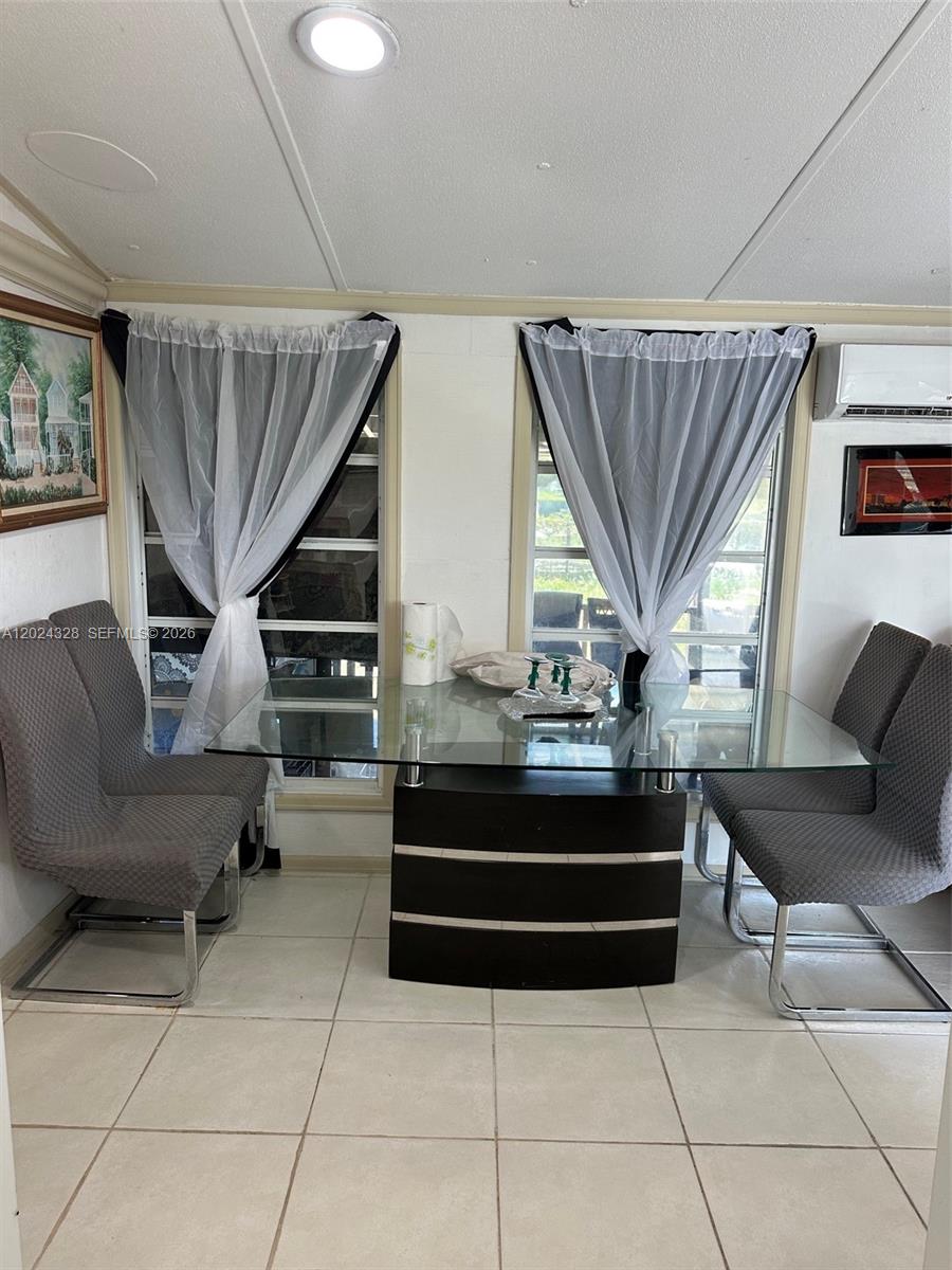 A dining area features a glass-topped table, four gray chairs, and two windows with curtains — 625 N QUEBRADA, Clewiston FL 33440, CLEWISTON, FL