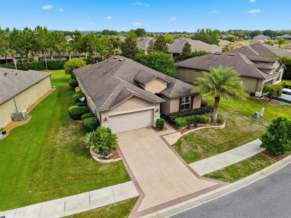 An aerial view shows a single-story house with a tan exterior, shingled roof, and driveway — 9641 SW 76TH PLACE, OCALA, FL