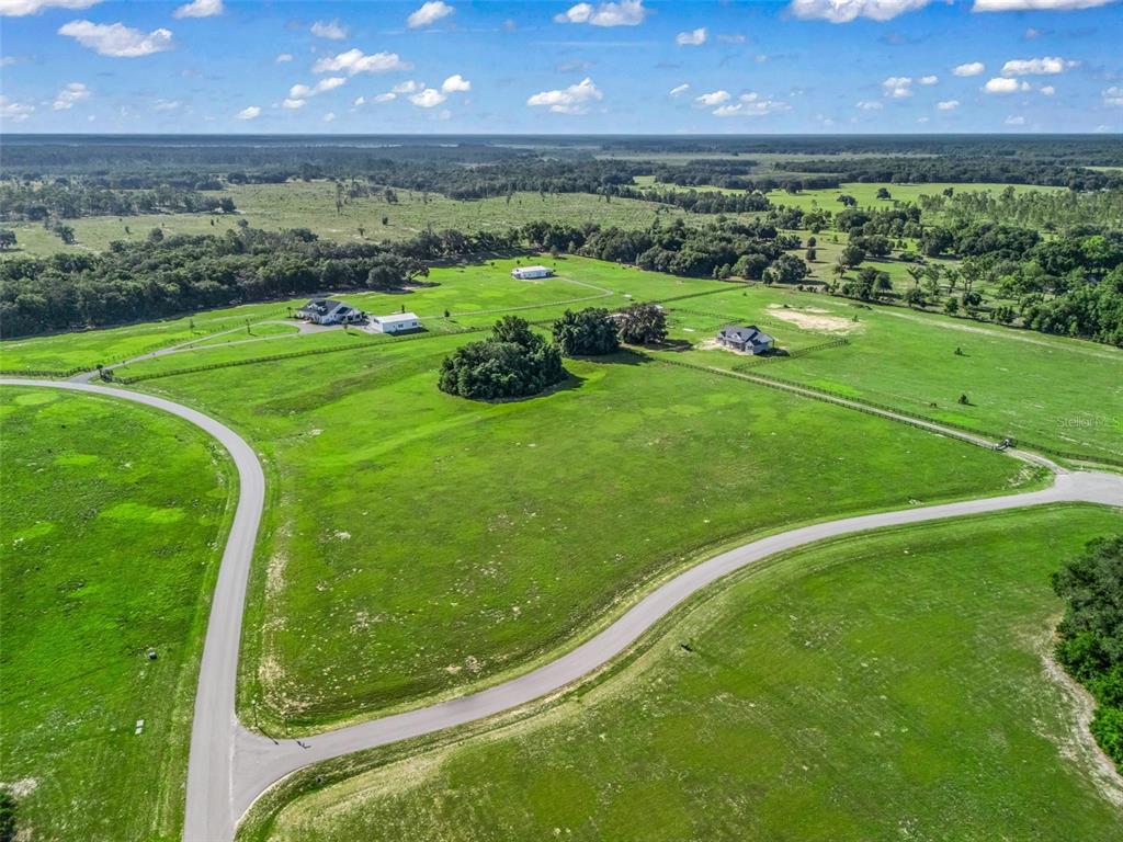 An aerial view shows a large, grassy rural lot with several houses and paved roads — 0 NE 54TH TERRACE, ANTHONY, FL