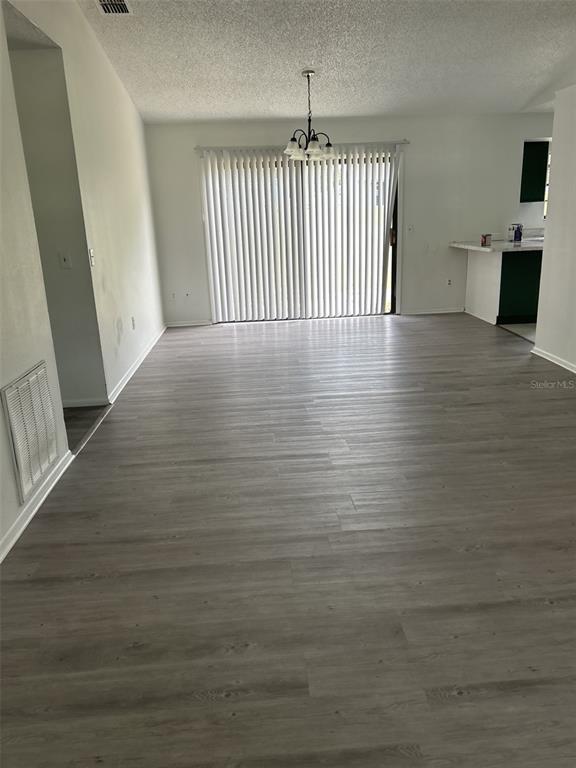 An open-concept living area features light gray wood-look flooring and a sliding glass door — 1028 HICKORY ROAD, OCALA, FL