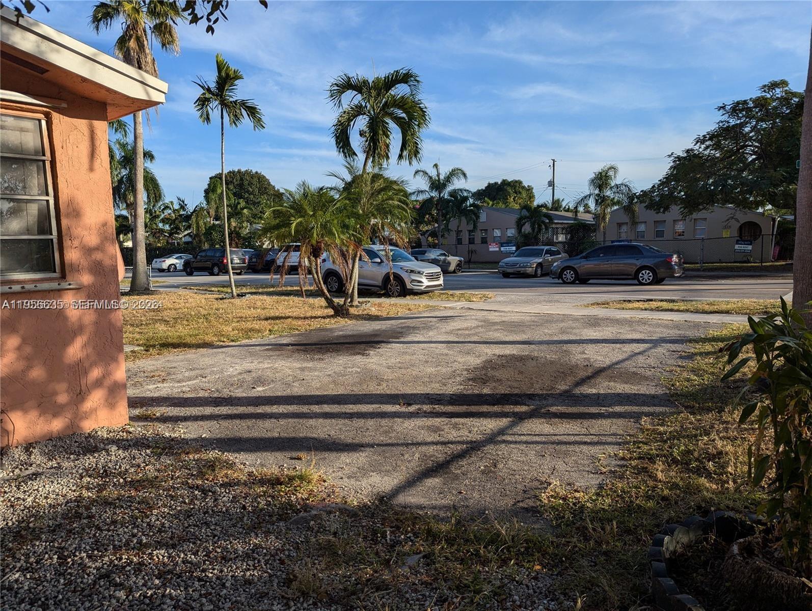 An exterior view shows a paved driveway in front of a house with palm trees — 1853 Taft St, Hollywood FL 33020, HOLLYWOOD, FL