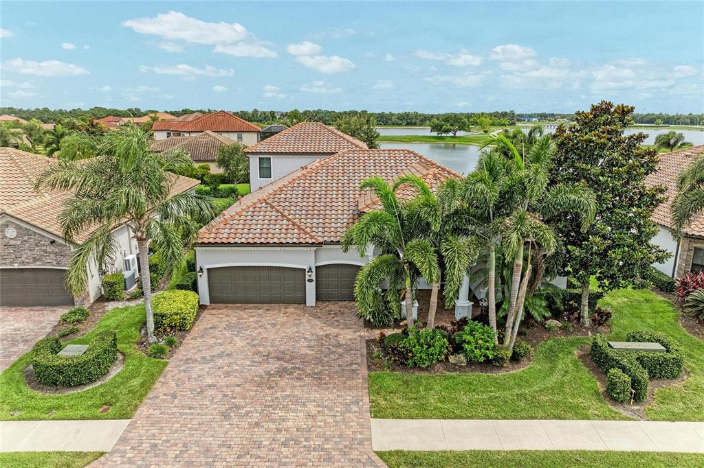 An aerial view of a single-story house with a tiled roof and a paved driveway — 13304 BRIDGEPORT CROSSING, BRADENTON, FL