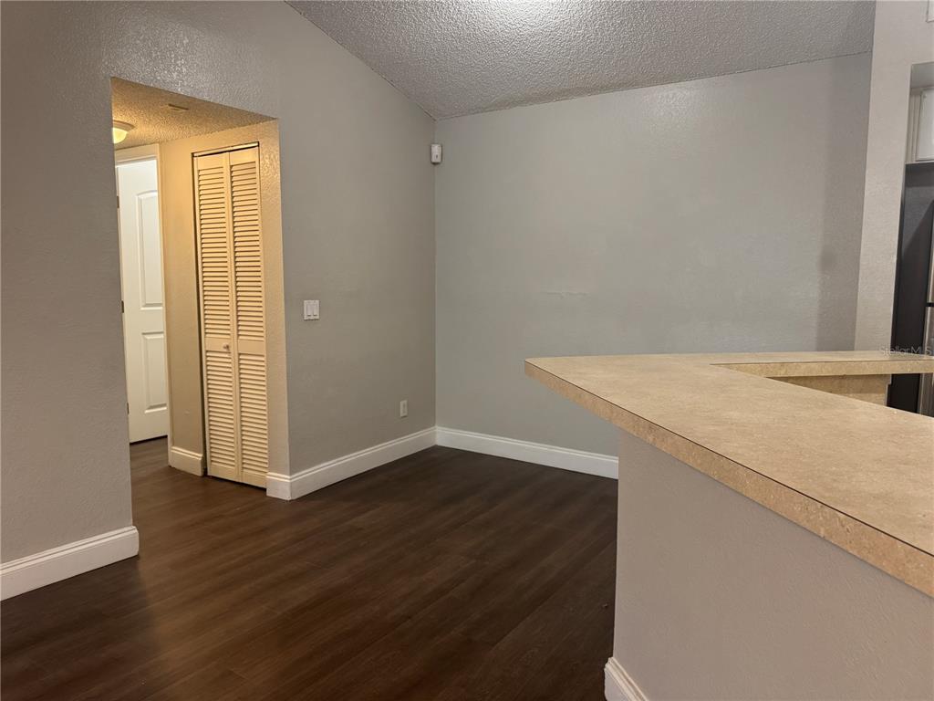 A view of a room with wood-look flooring, a breakfast bar, and a closet — 4532 COMMANDER DRIVE UNIT 2131, ORLANDO, FL